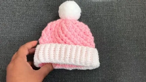 Crochet baby hat with ribbon band and pom-pom