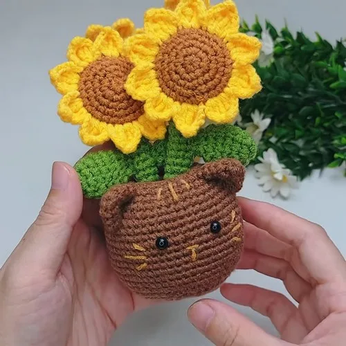 Crochet cat planter with a sunflower bloom